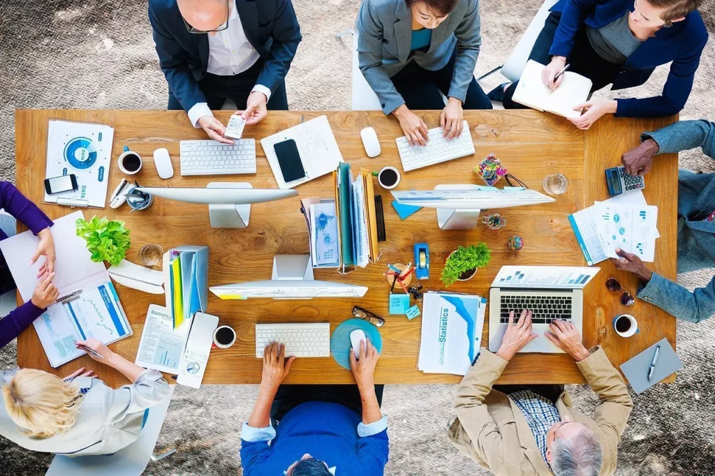 Business people meeting at conference table with various devices